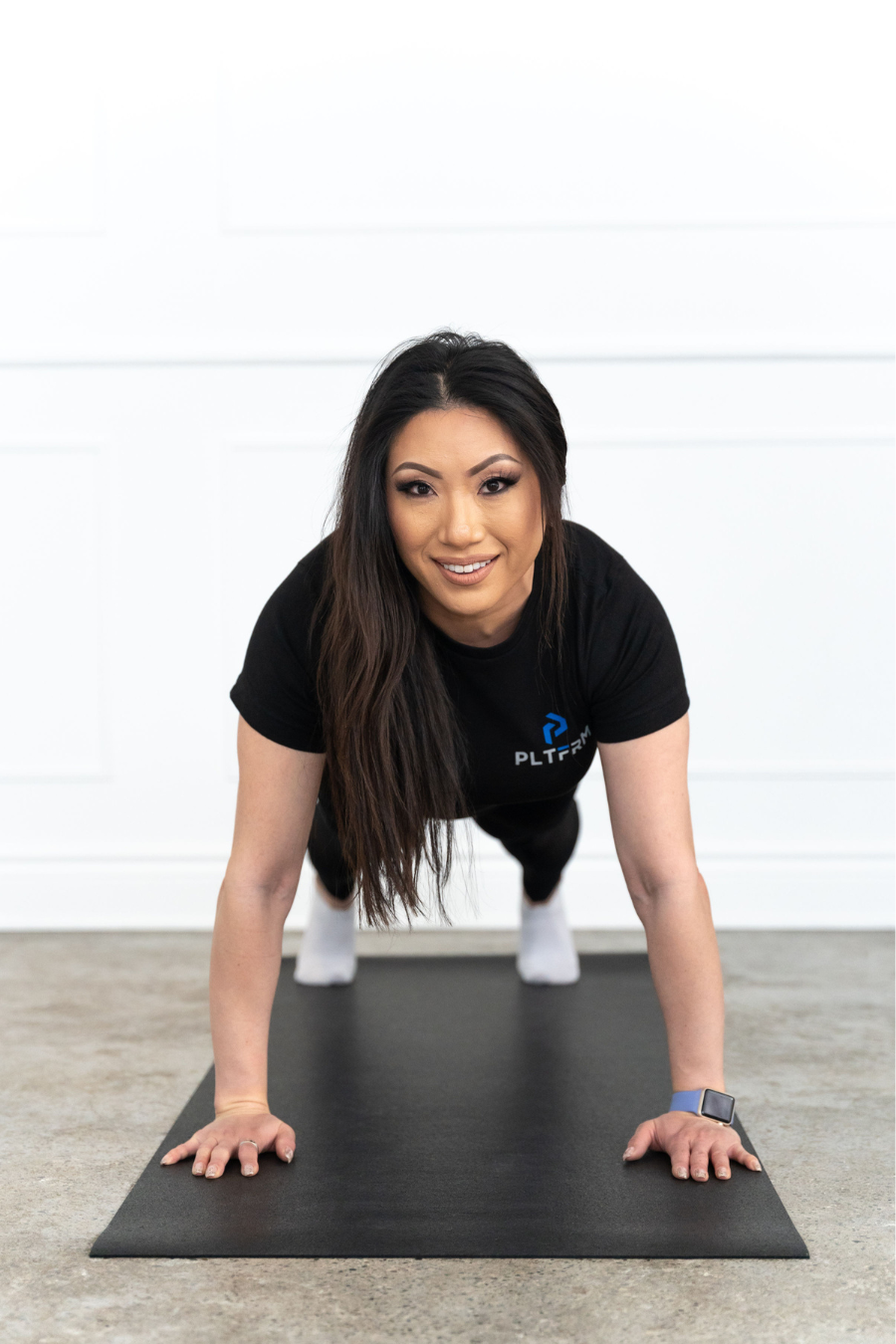 Female personal trainer wearing a PLTFRM T-shirt and holding a plank pose