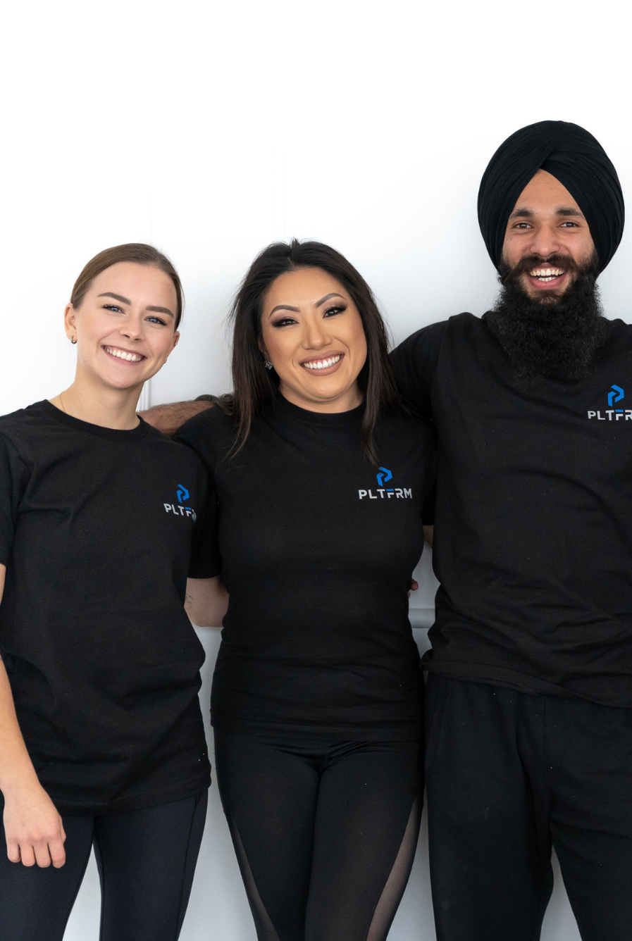 Three personal trainers standing together and smiling